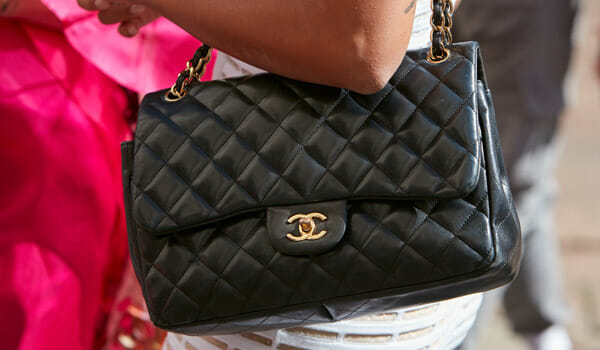 Black Chanel classic flap bag why are they so expensive